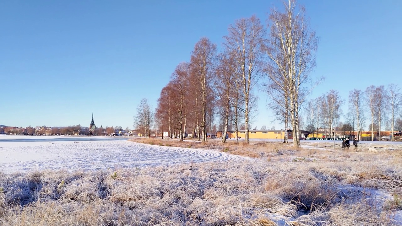 一个阳光明媚的冬日，瑞典小镇莫拉，结冰的湖面上覆盖着积雪视频素材