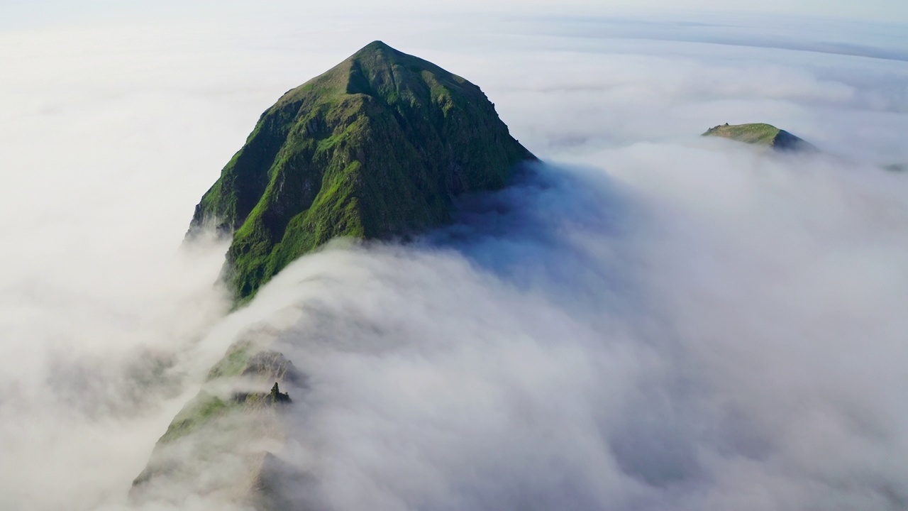 非常棒的航拍全景。高高的绿色山脊周围覆盖着浓密的白云视频素材