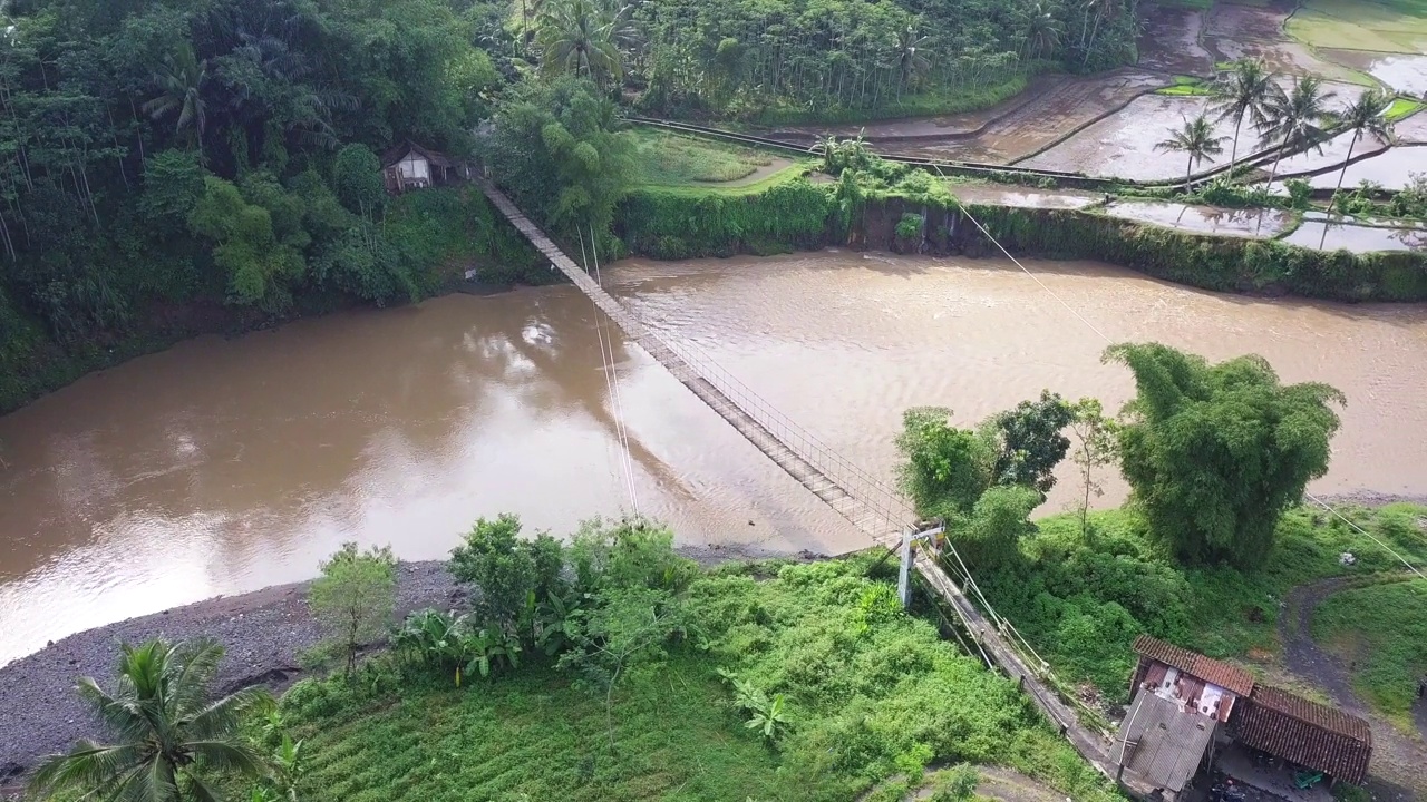 一座建在大河上的木制吊桥，作为村民进出村庄的通道视频素材