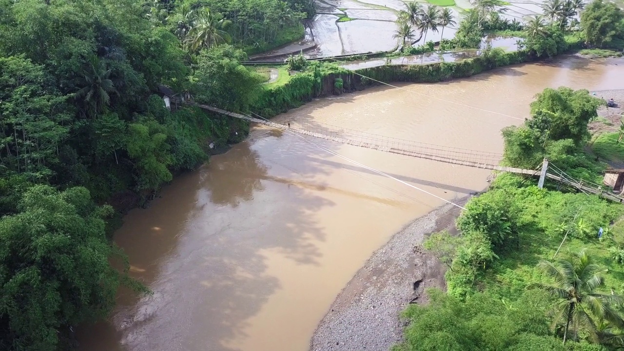 一座建在大河上的木制吊桥，作为村民进出村庄的通道视频素材