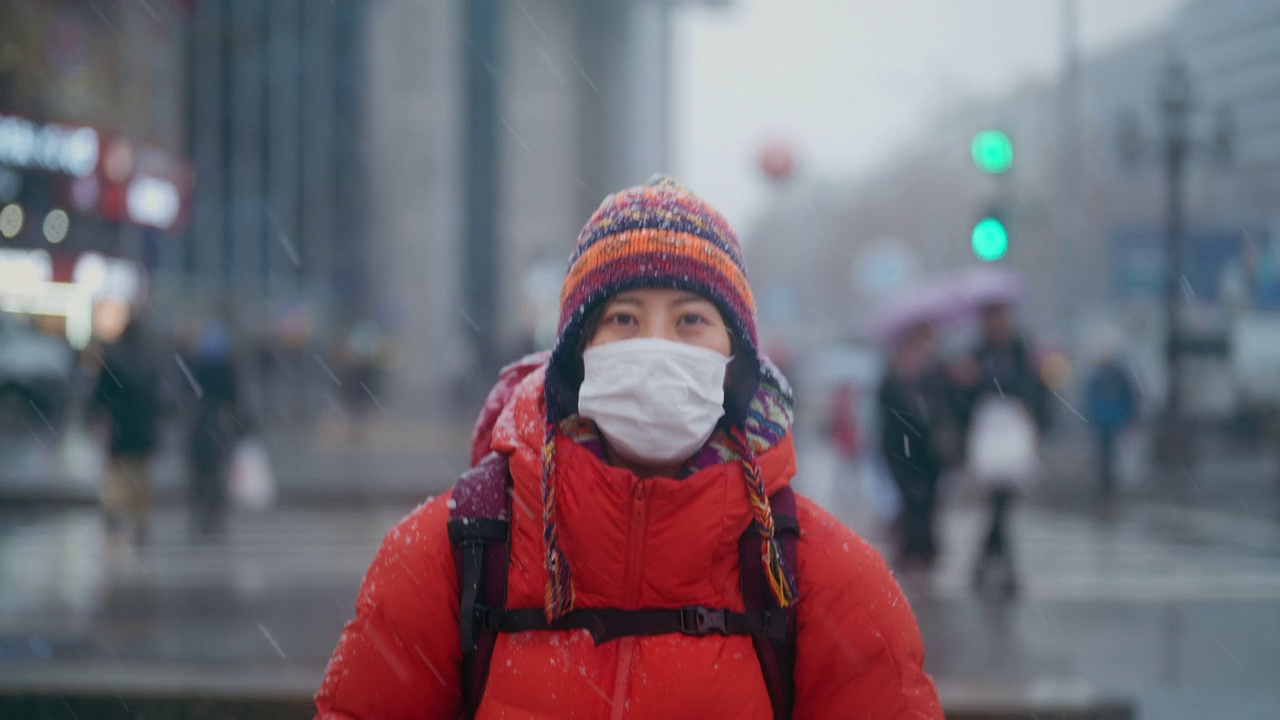 年轻的女游客在冬天的城市观光和过马路视频素材