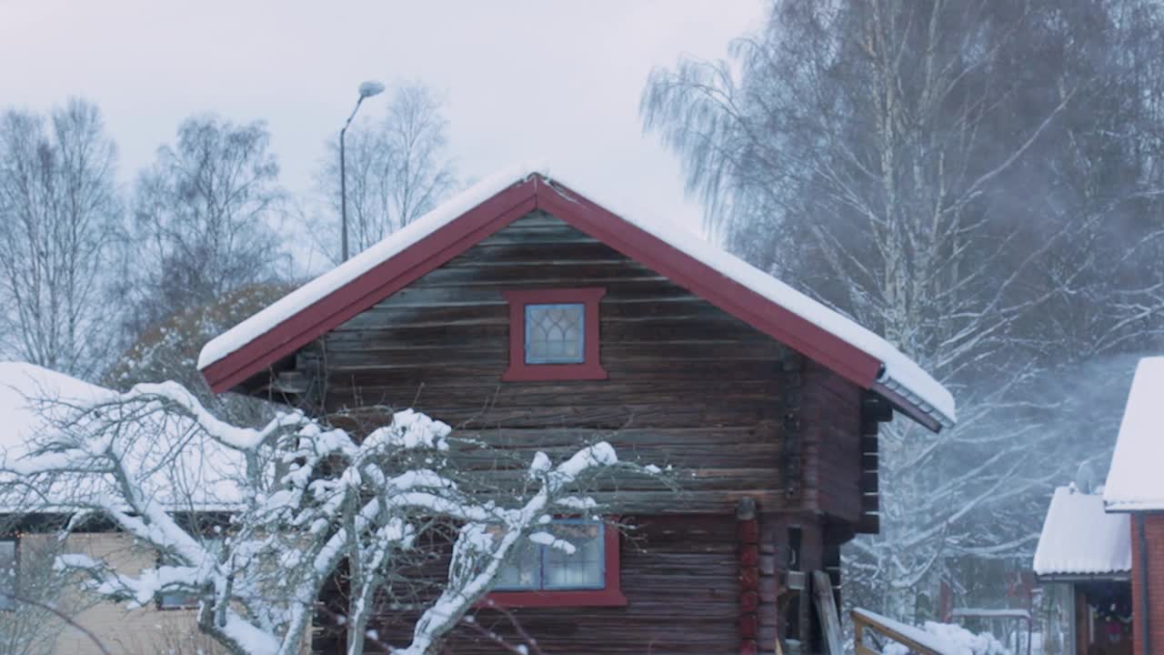 雪在风中飘飘，围绕着一座小木屋视频下载