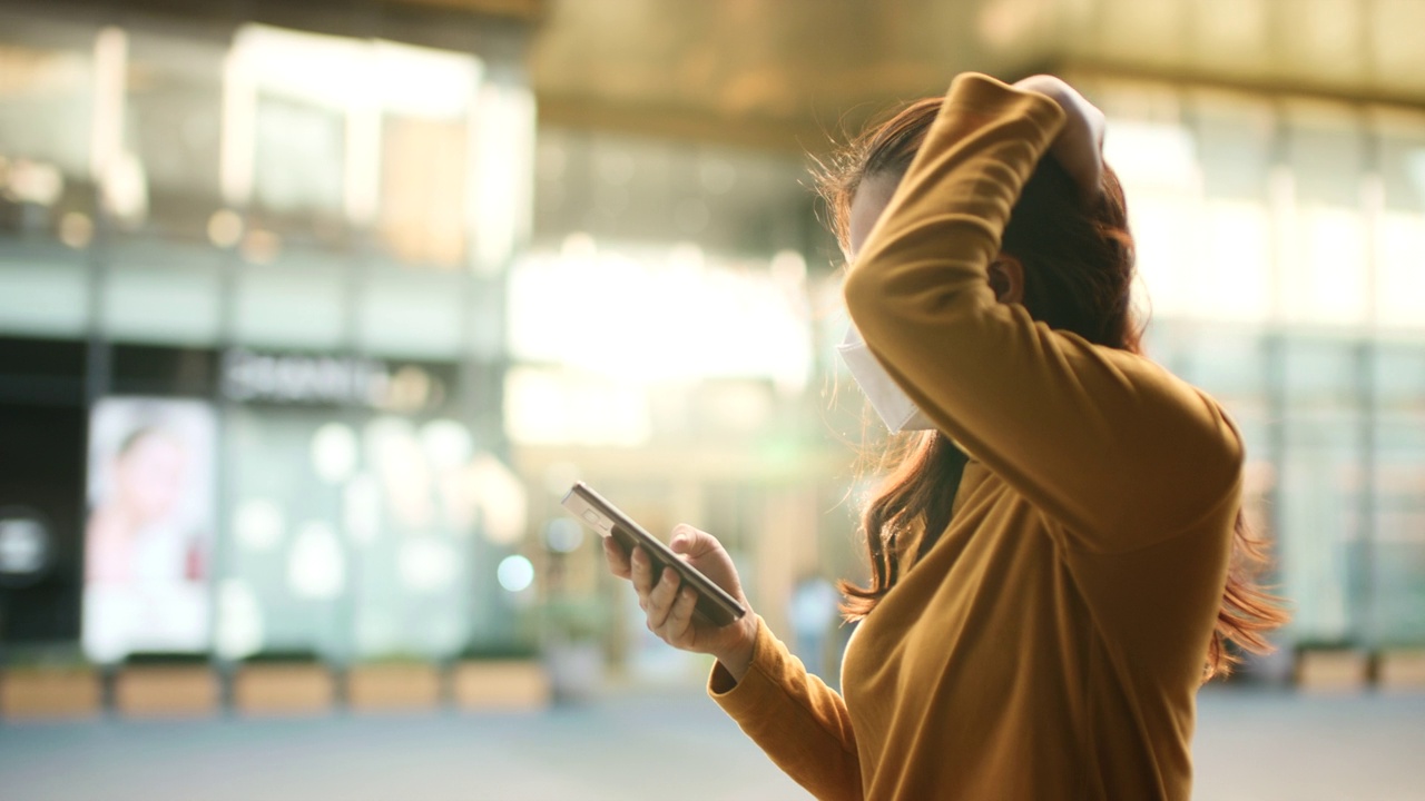 女子用智能手机防病毒口罩视频素材