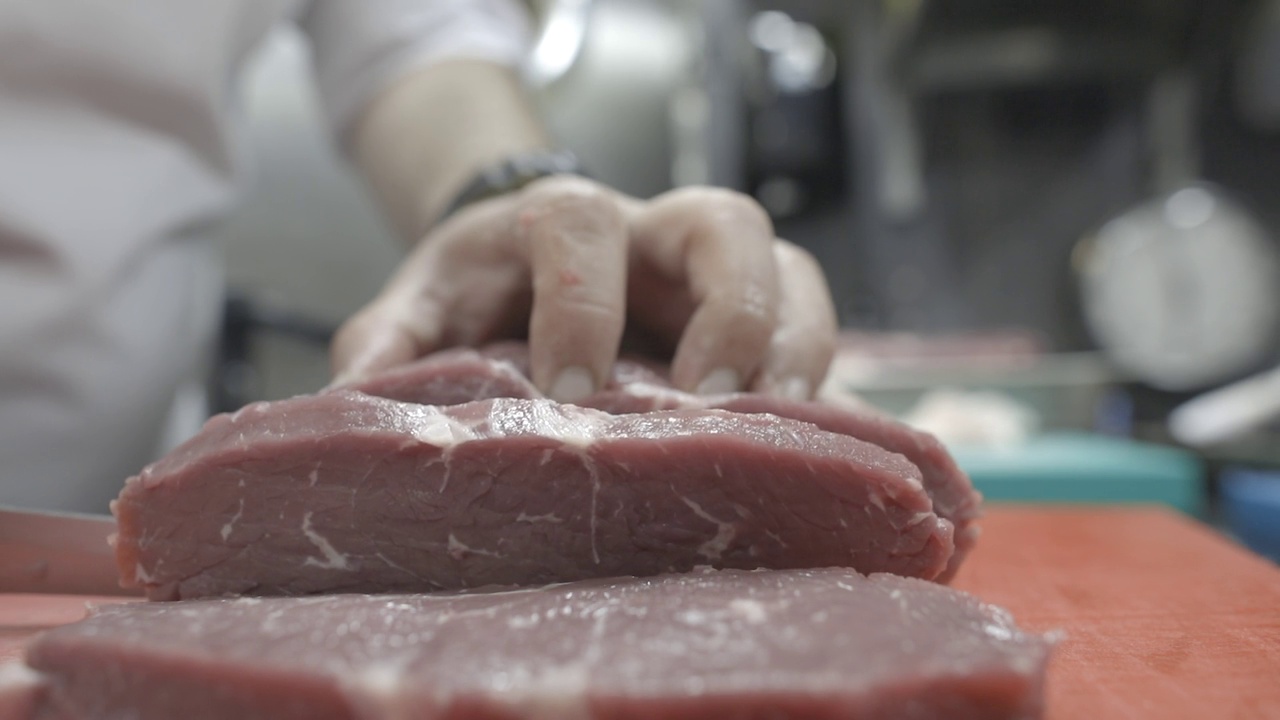 人刀在砧板上切生肉牛肉，切刀精准。日志的形象视频下载