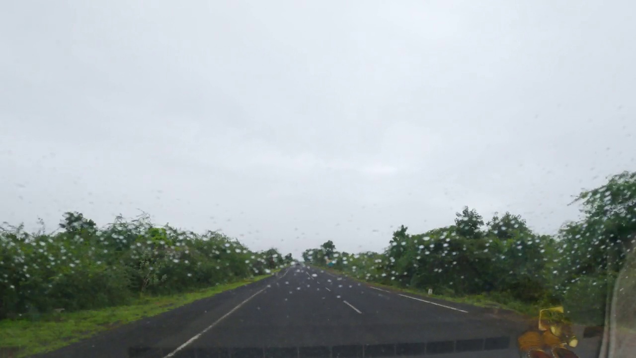 在一个美丽的雨季，驱车行驶在印度的乡村公路上。间隔拍摄hyperlapse drivelapse。森林和多云的天空视频素材