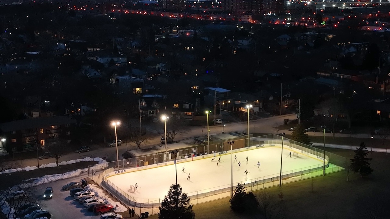 鸟瞰图，在冰雪覆盖的城市公园的运动场上空飞行。多伦多视频素材