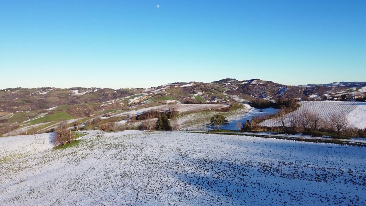 鸟瞰图中的意大利乡村在冬天覆盖着小雪，留下了长长的阴影。视频素材