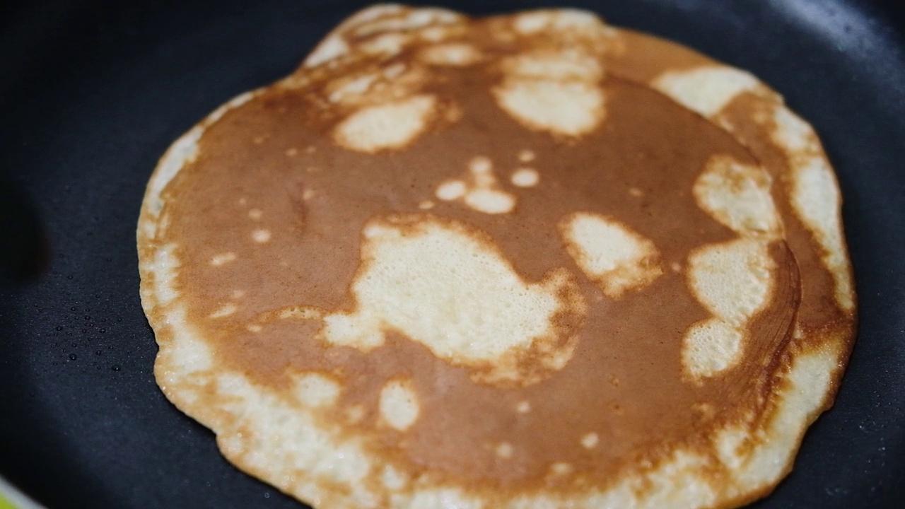 烹饪法式薄饼。厨师在平底锅里翻动薄煎饼。狂欢节和忏悔星期二的传统食物。视频素材