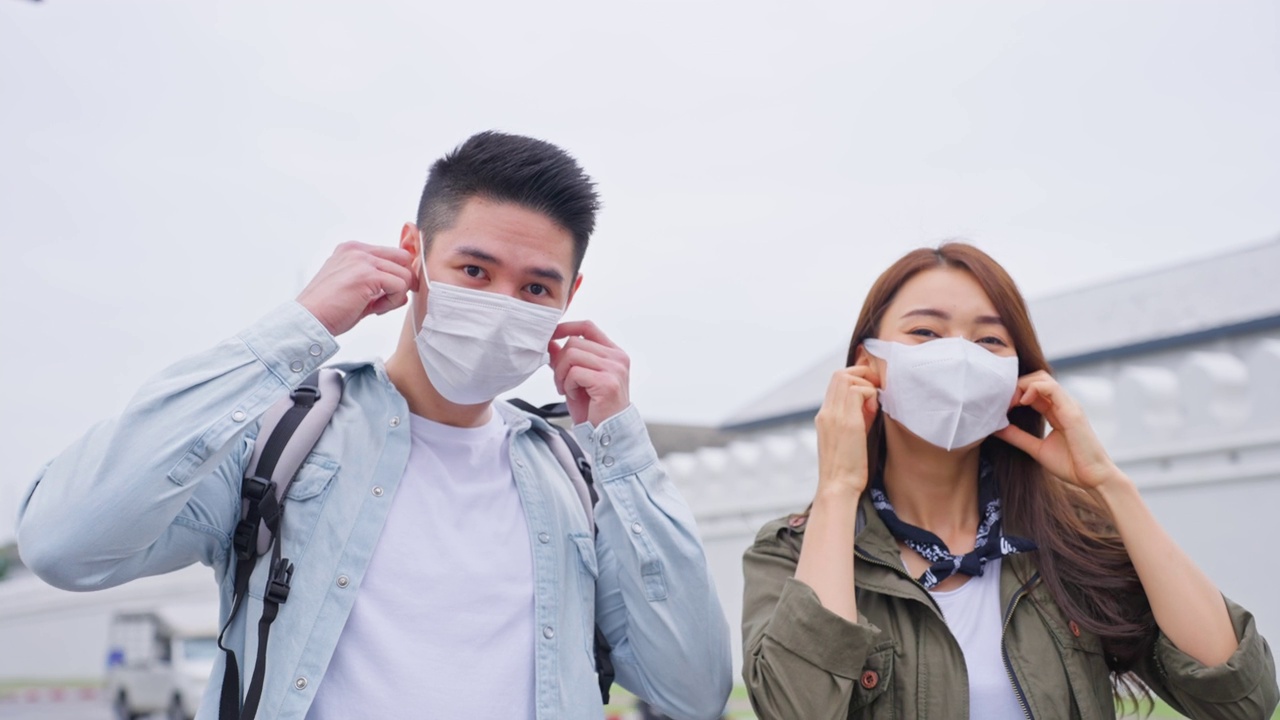 亚洲年轻夫妇在城市度蜜月旅行的写真新婚男女背包客在泰国，手挽着手，看着相机，一起享受假期。视频素材