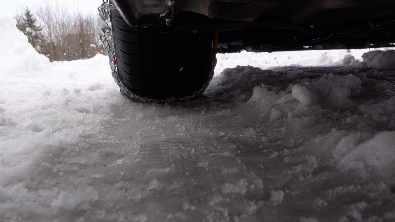 特写轮胎与雪链驾驶在雪和结冰的道路视频素材