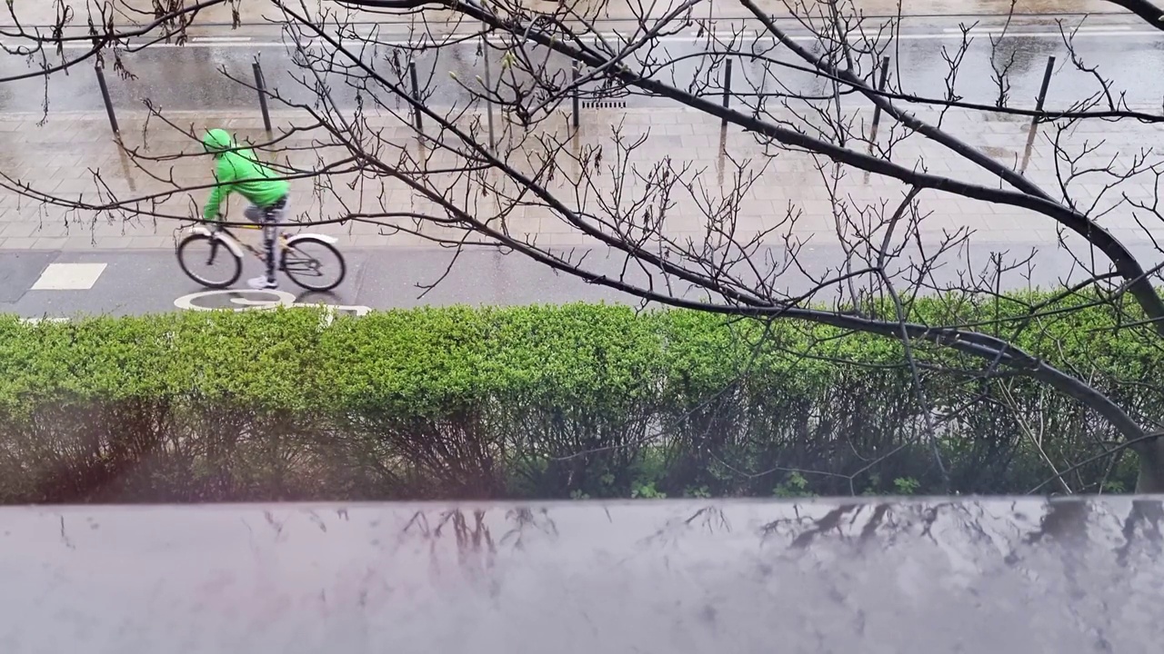 外面的天气不好。带来了雨和冰雹。只是偶尔会有汽车和骑自行车的人经过视频素材