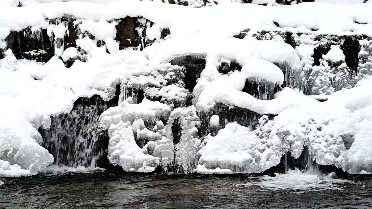 积雪覆盖和冻结的瀑布在山上的小溪。比斯兹扎迪山脉，喀尔巴阡山脉，波兰。视频下载