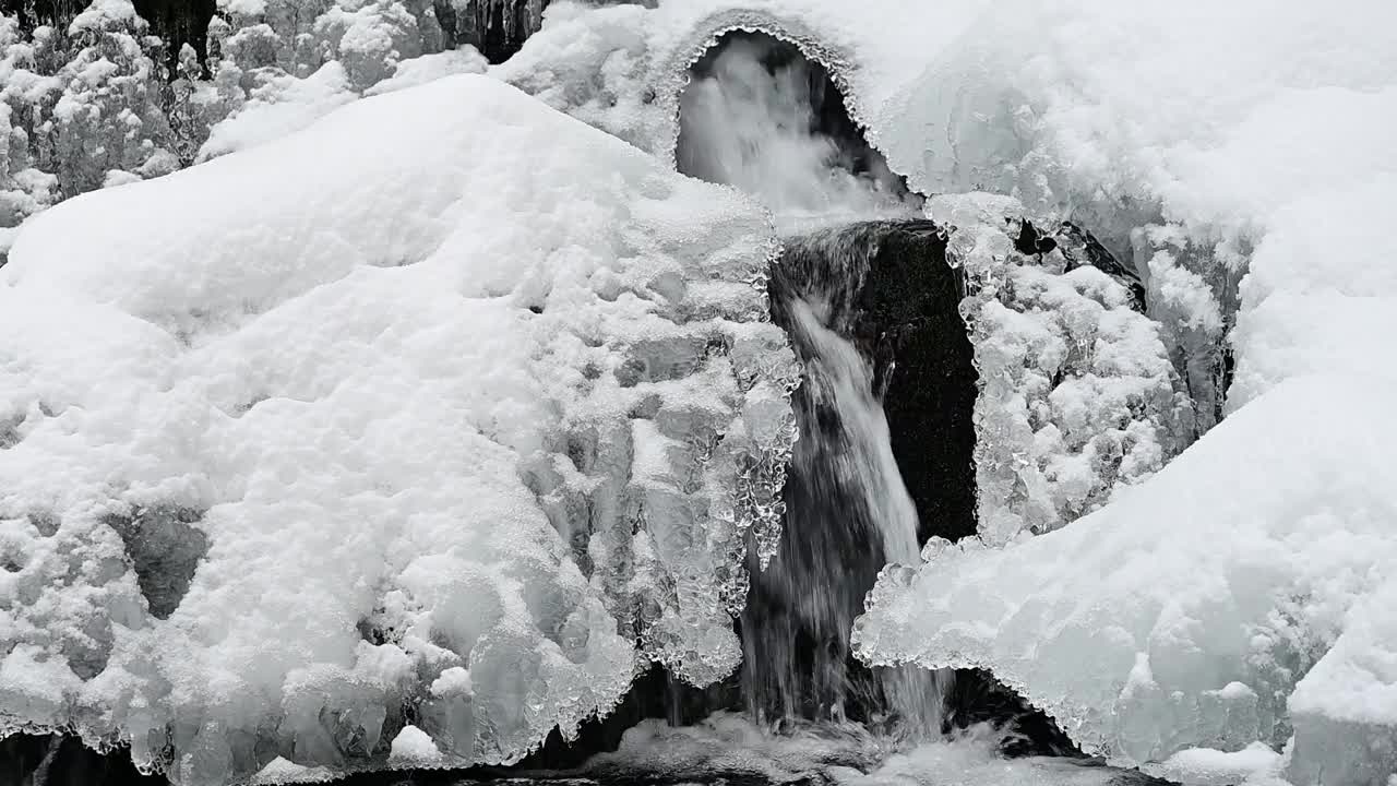 积雪覆盖和冻结的瀑布在山上的小溪。比斯兹扎迪山脉，喀尔巴阡山脉，波兰。视频下载