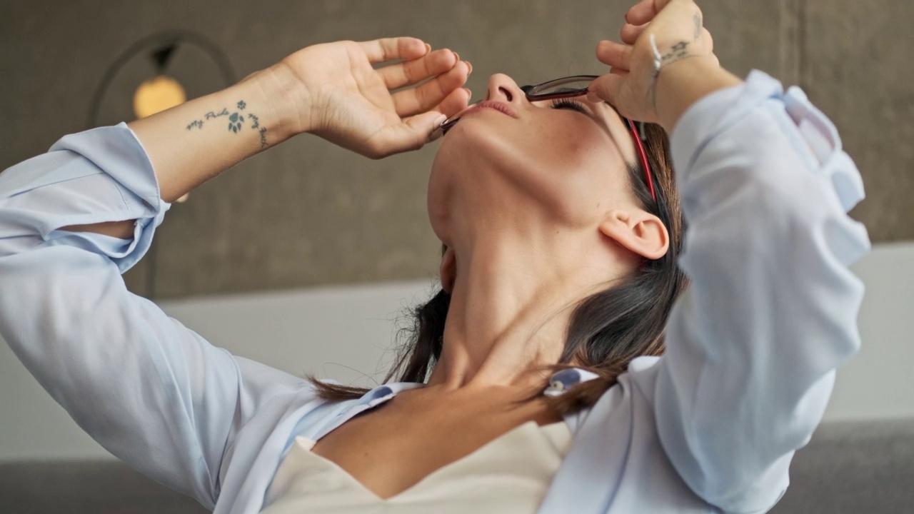 近距离观察疲惫的漂亮的商业妇女摘下她的眼镜，用手指揉她的眼睛视频素材