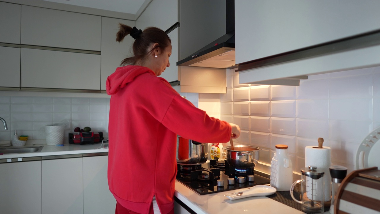 成熟的女人在厨房做饭。视频素材