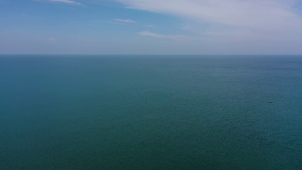 开阔的蓝色海洋，海浪映着天空和云彩视频素材