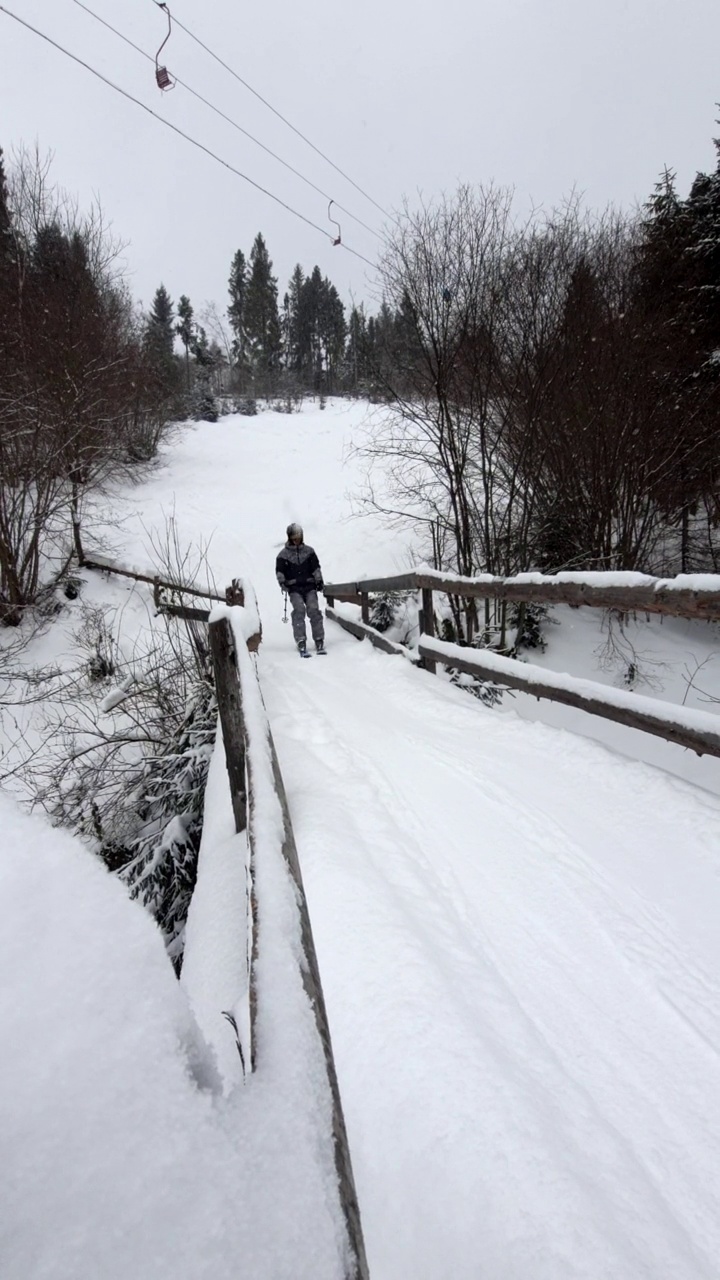 男子在经过桥的斜坡上滑雪视频素材