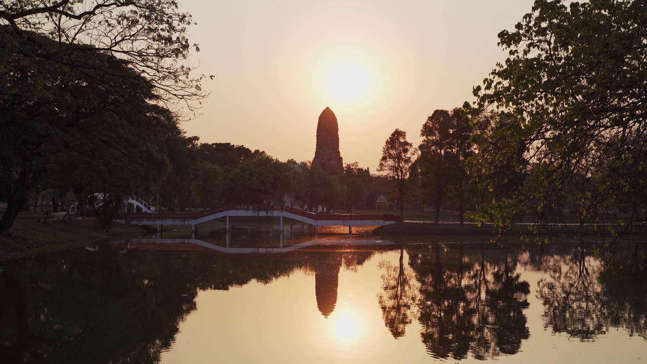 日落时分带池塘湖的健身公园在古庙中。剪影景观古代大城府遗址在水中的倒影。视频下载