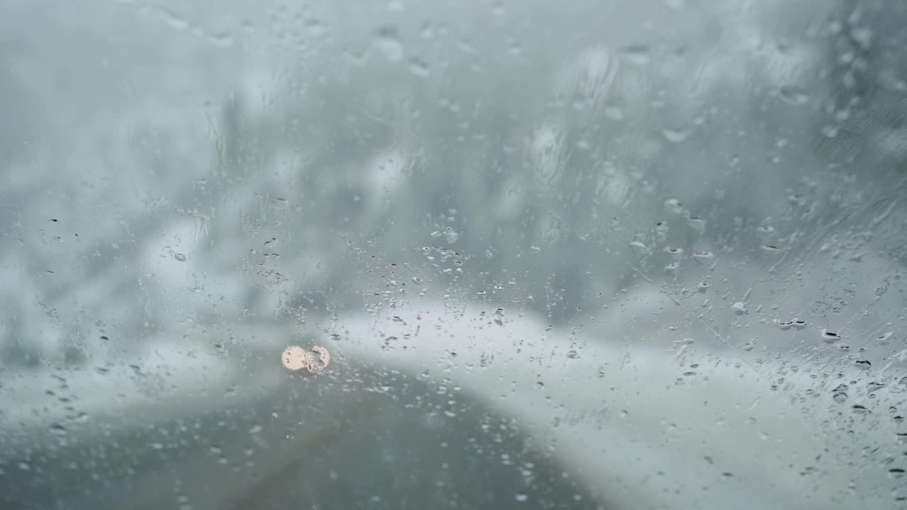 在高速公路上行驶的汽车挡风玻璃上飘落的雪视频素材