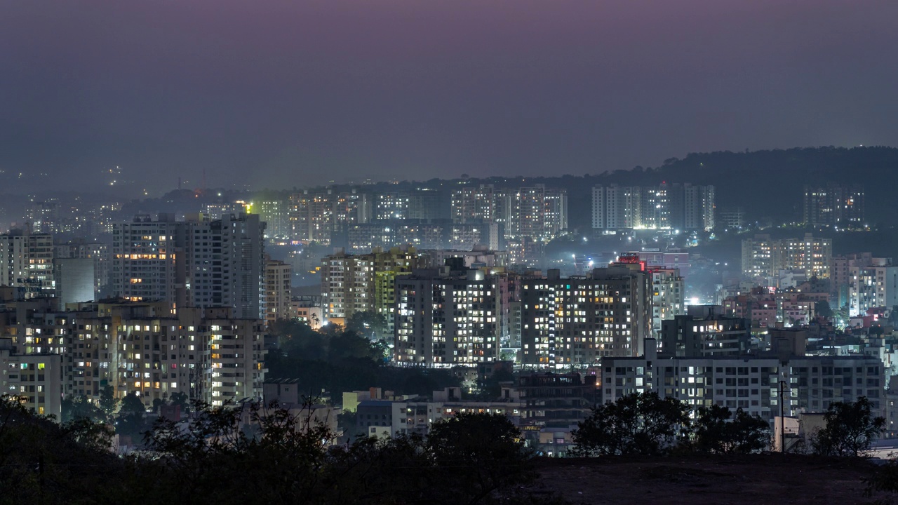 日落在山后的时间推移和白天到夜晚的城市景观过渡，马哈拉施特拉邦，印度视频素材