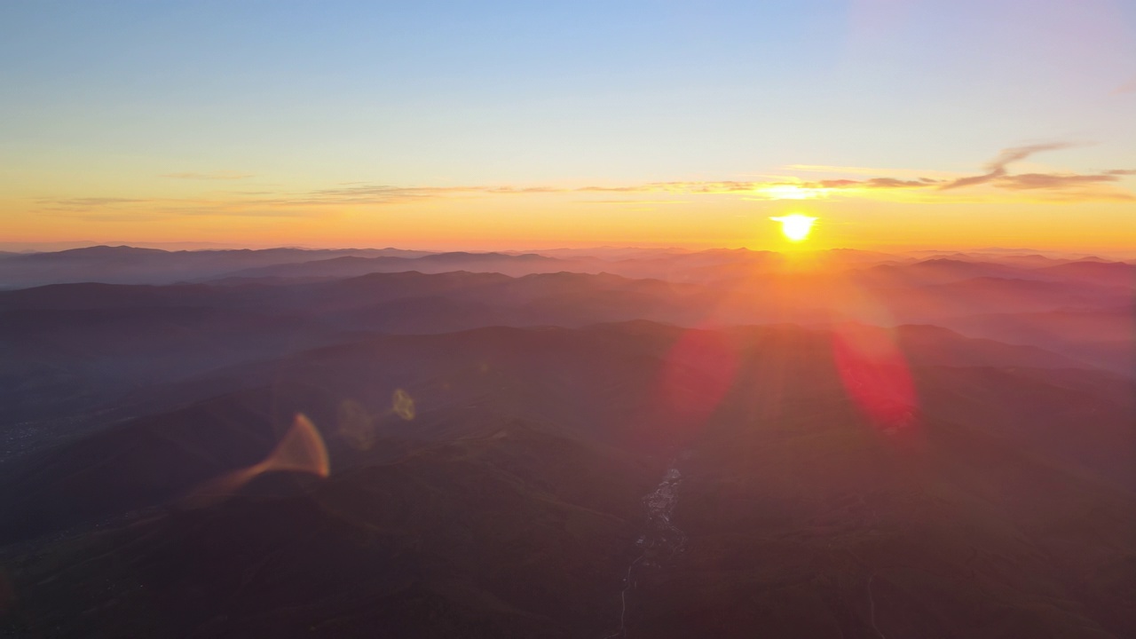 从空中俯瞰，日落时分，黑黝黝的小山和明亮的夕阳。傍晚朦胧的山峰和朦胧的山谷视频素材