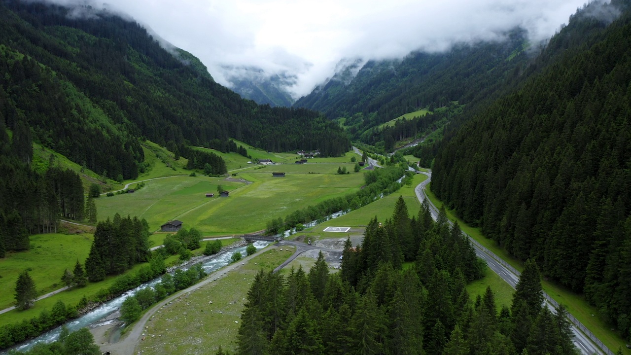 航拍画面显示山谷中有河流、公路和松树林。奥地利蒂罗尔州视频素材