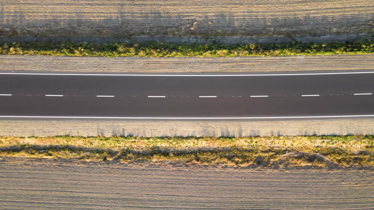 鸟瞰图的城际道路与快速行驶的汽车在日落。俯视图从无人机公路交通在晚上视频素材