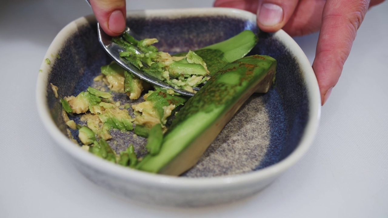 制作鳄梨酱三明治，用厨房叉子挤牛油果汁视频素材