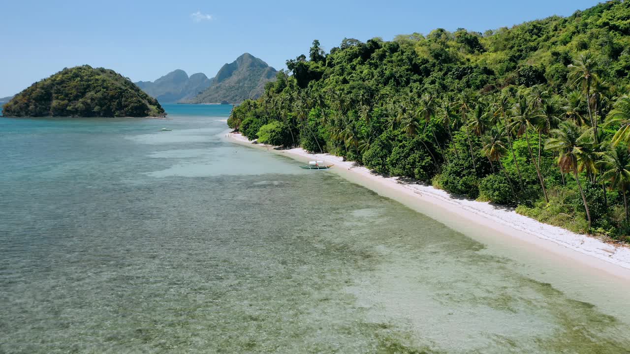 4k无人机在浅水碧水上空盘旋，椰子树在海风中摇摆。探索菲律宾巴拉望岛的厄尔尼诺岛视频素材