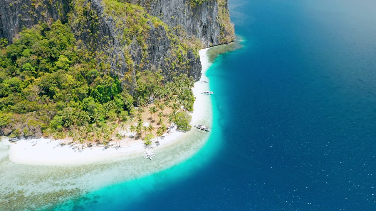 惊人的Pinagbuyutan岛。El Nido，巴拉望岛，菲律宾。天堂般的热带沙滩Ipil海滩，蔚蓝的海水，椰子树和当地的船停泊视频素材