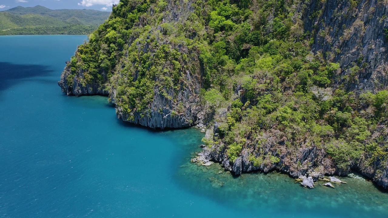 一个不可逾越的岩石悬崖岛屿的4k鸟瞰图。El Nido，巴拉望岛，菲律宾。被蓝色海水环绕的巴基特湾未受破坏的岛屿视频素材