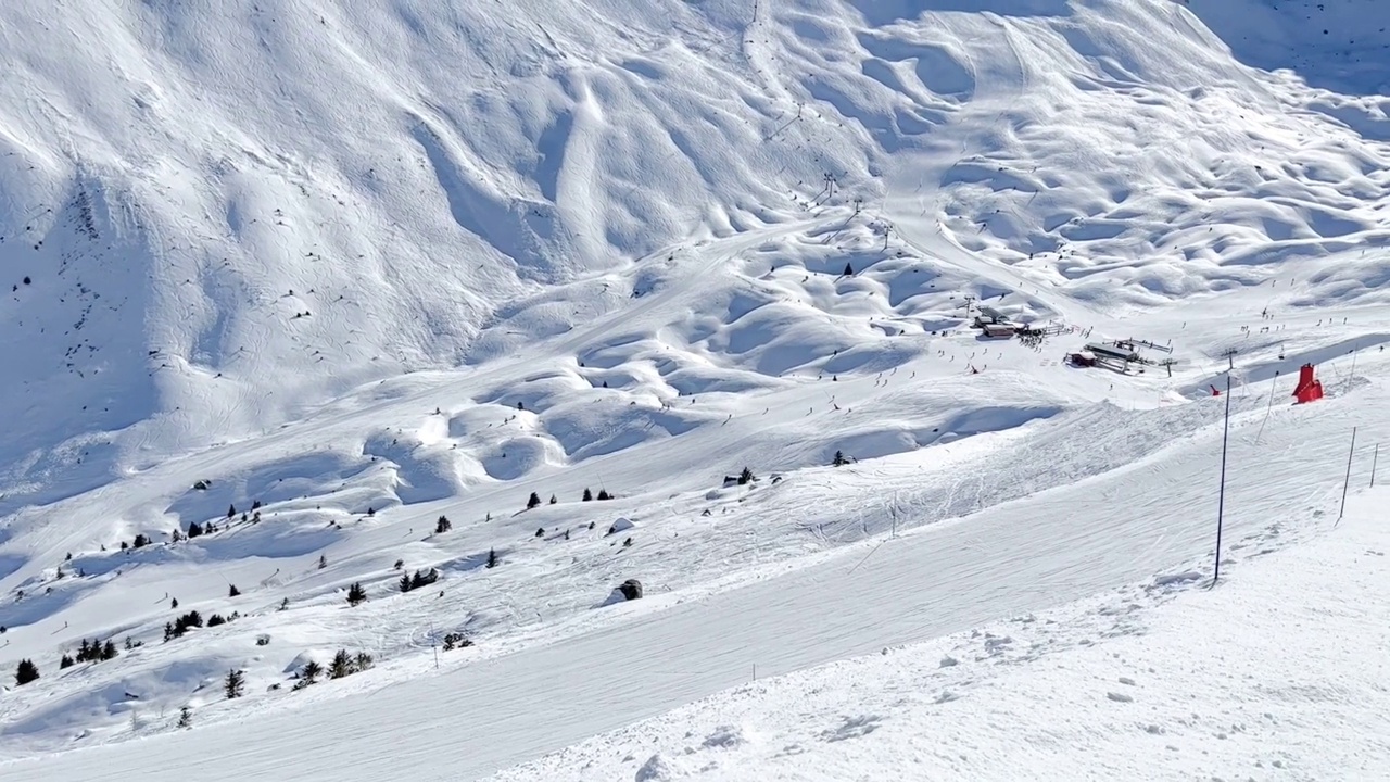 人们在著名的滑雪胜地Courchevel宽阔的斜坡上滑雪视频素材