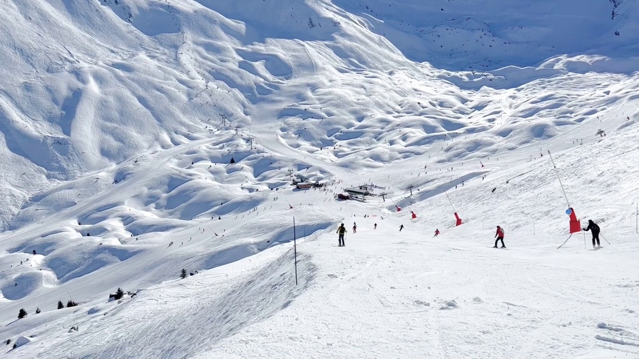 人们在著名的滑雪胜地Courchevel宽阔的斜坡上滑雪视频素材