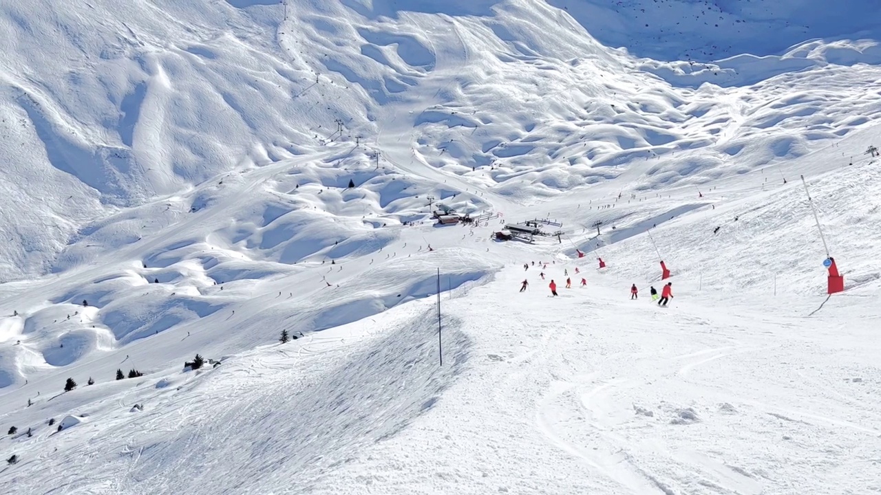 人们在著名的滑雪胜地Courchevel宽阔的斜坡上滑雪视频素材