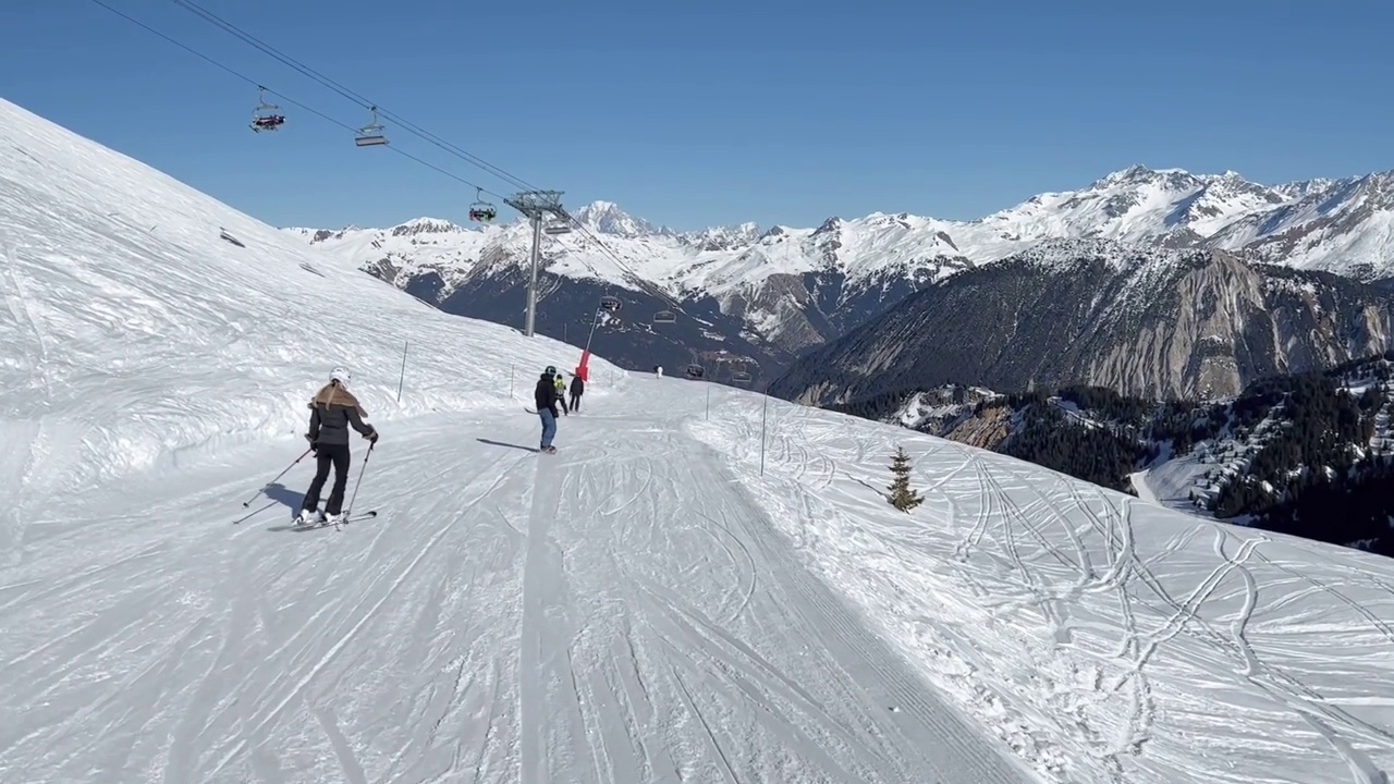 人们在著名的滑雪胜地Courchevel宽阔的斜坡上滑雪视频素材