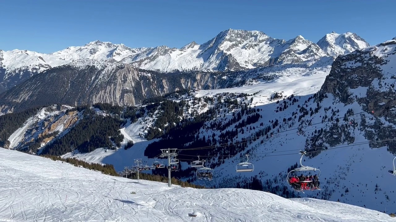 人们在著名的滑雪胜地Courchevel的滑雪斜坡上乘坐升降椅上山视频素材