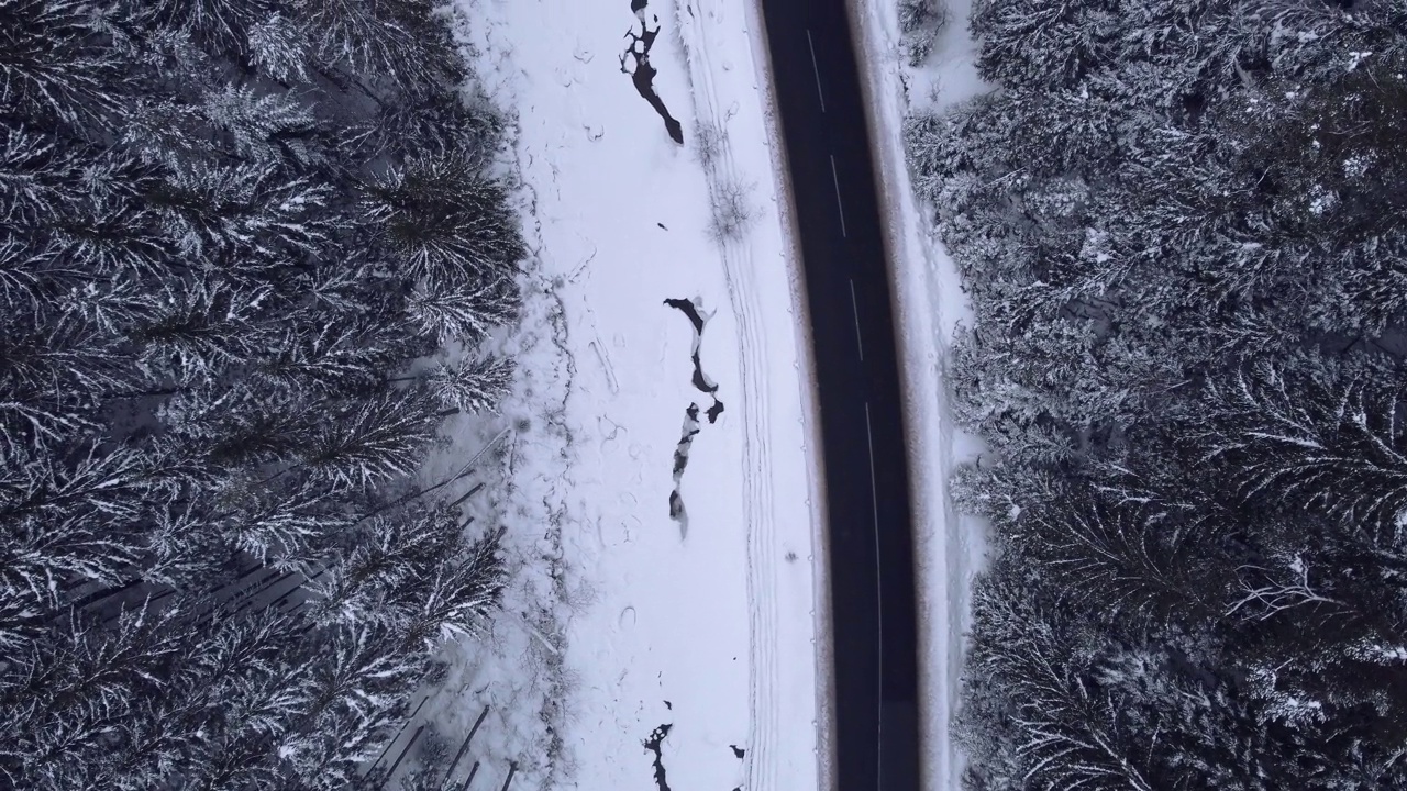 鸟瞰图雪山森林与汽车驾驶冬季道路。视频素材