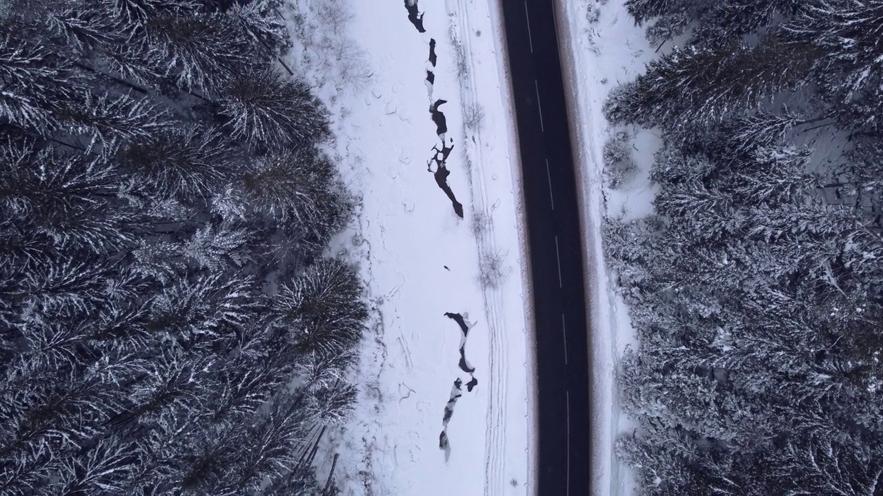 鸟瞰图雪山森林与汽车驾驶冬季道路。视频素材