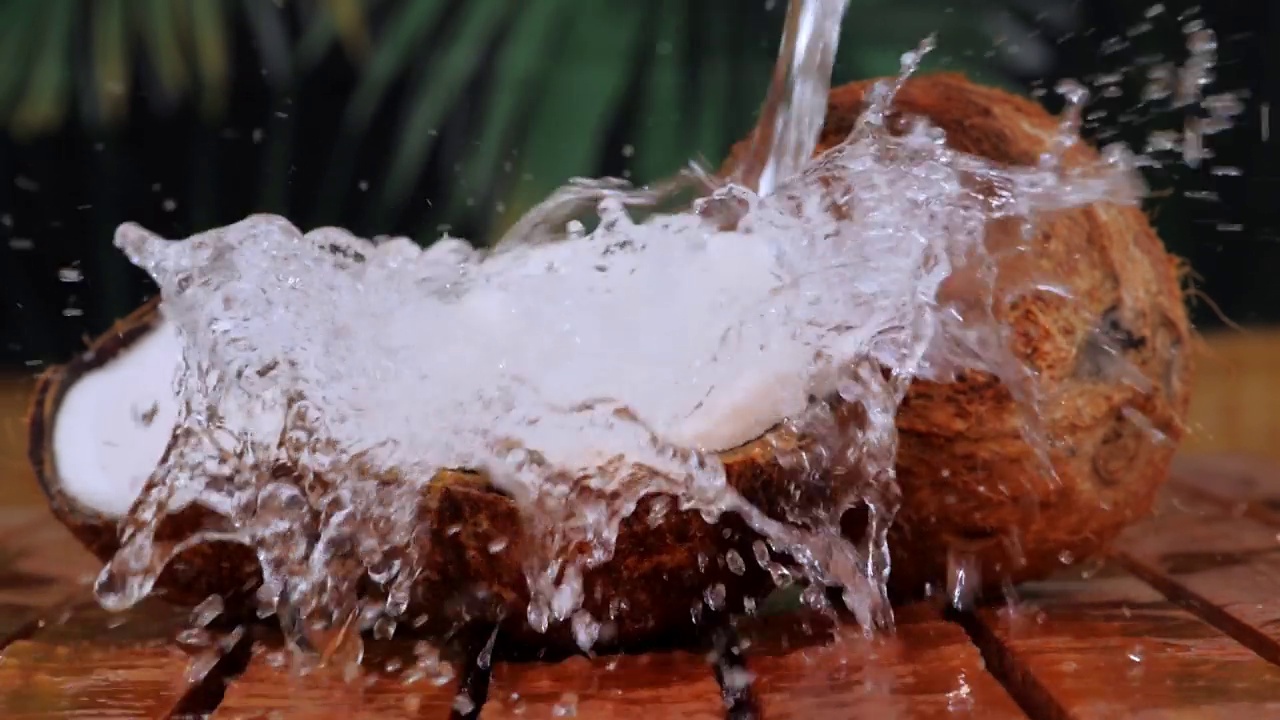 在木桌上用溅水的椰子碎。视频素材