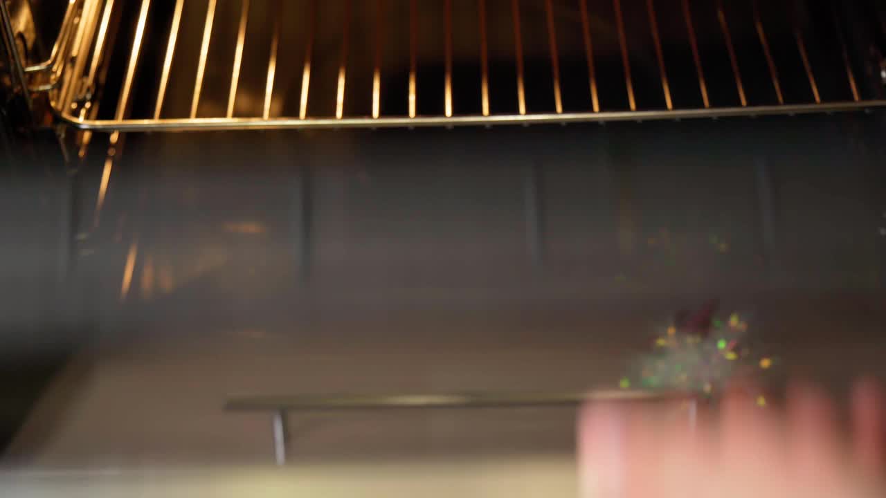 在黑色背景的烤盘里放上大蒜和香草烤鸡腿。烹饪的食物视频素材