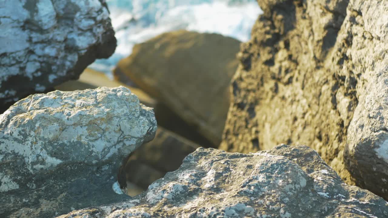 蓝蓝的海浪拍打在岩石山的悬崖上。视频素材