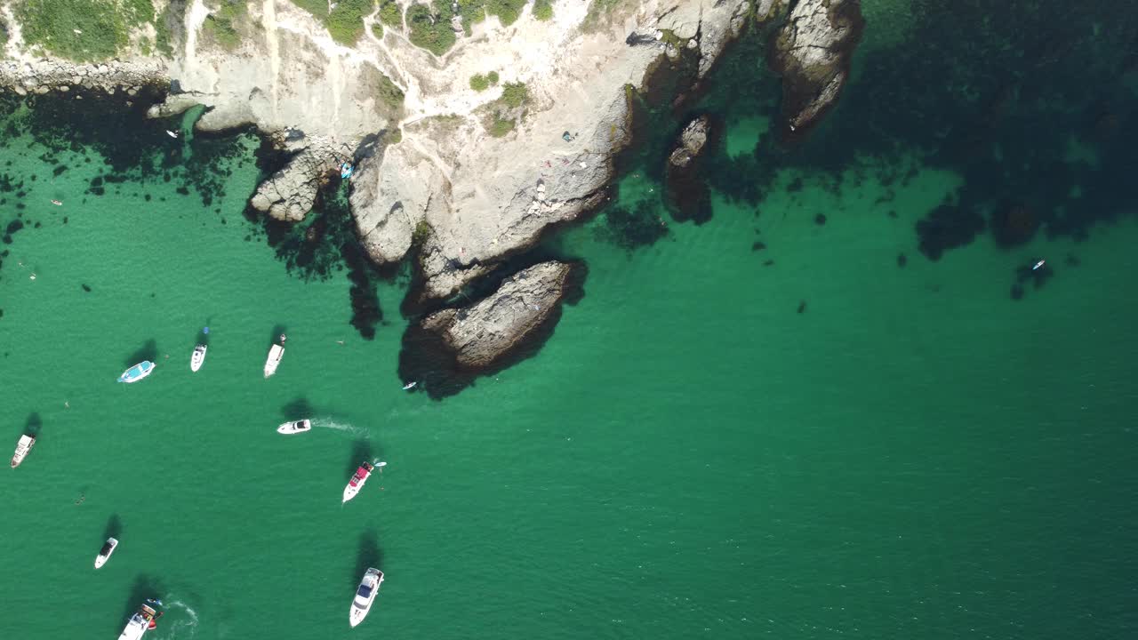 空中全景海景与湛蓝的大海和岩石海岸。在岩石的背景下，美丽的泻湖上的游艇。是夏季旅游和度假的理想目的地视频素材