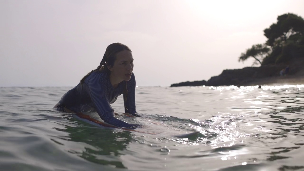 冲浪的女人在大海里等待着海浪视频素材