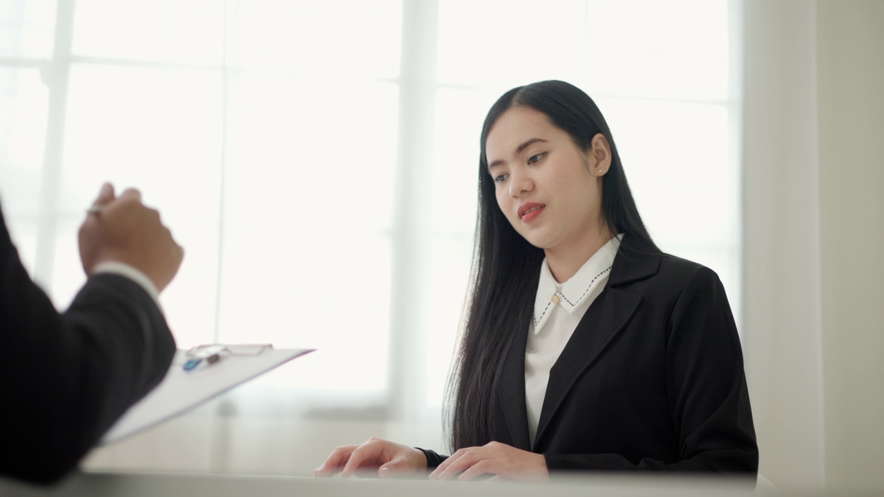 一名聪明的亚洲女性在求职面试前向人力资源部门的工作人员打招呼。快乐的女人寻求者或保险经纪人提出一项业务。女商人发送简历。视频素材