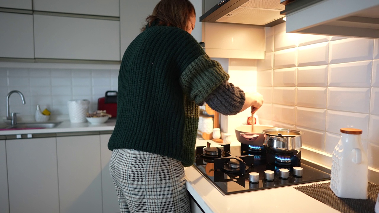 一个女人正在厨房里做饭。视频素材