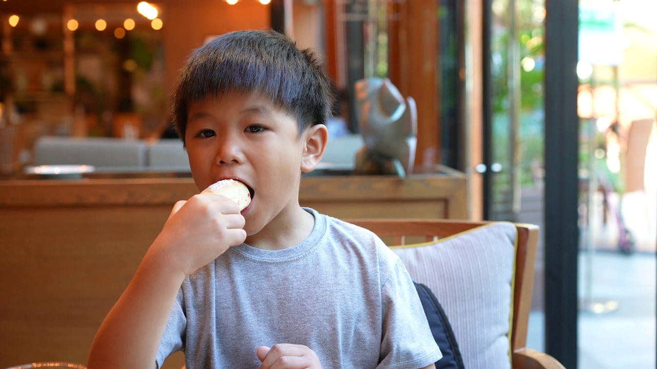 亚洲小孩早餐喝一杯牛奶。健康早餐的概念视频素材