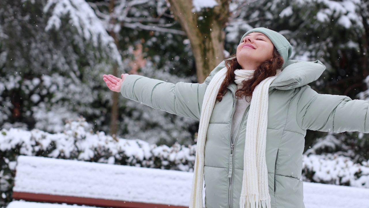 年轻女子享受着一个下雪的冬日视频素材