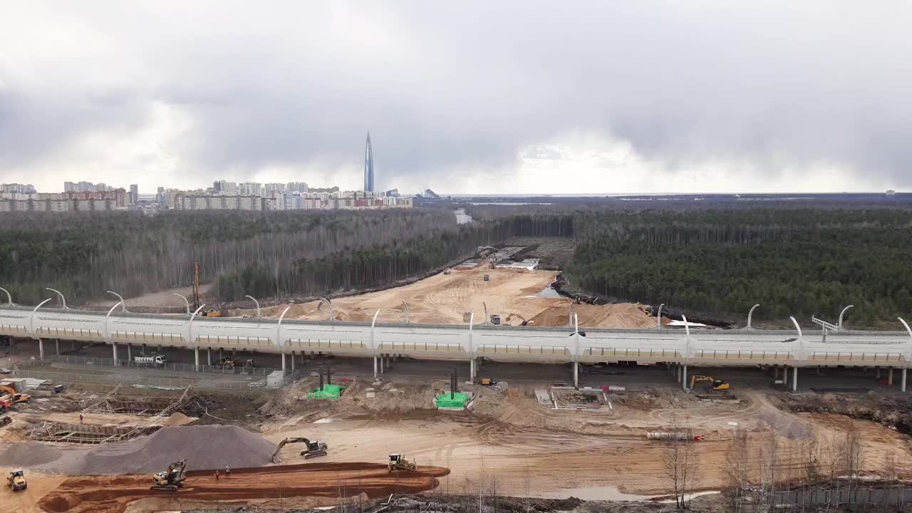 工业挖掘机在露天路段用自卸车装载岩土。挖掘机铲斗滴水和装载。道路建设。道路建设。平地机和滚轮工作视频素材