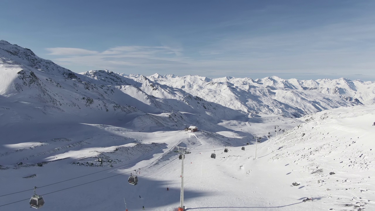 鸟瞰图，滑雪缆车与滑雪者在一个雪天寒冷的冬季景观崎岖的山峰，因为它通过山谷视频素材