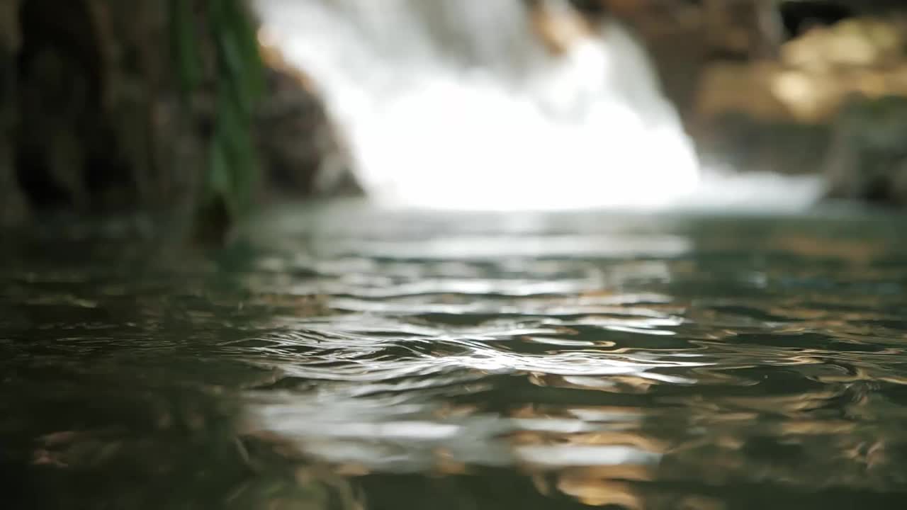 用手舀取森林中的清溪瀑布，用手缓慢移动洁净的水，水资源，地球，环境，养护。视频素材